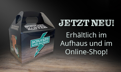 Der ADS Schocken-Koffer steht auf einer Holzfläche.